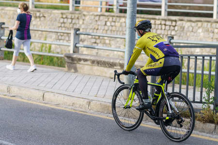 Man riding bike, wearing mask, as protection from the Covid-19 pandemicのeditorial素材