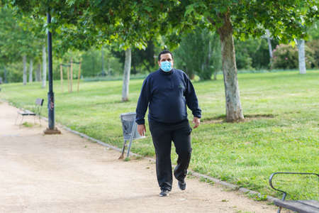 Fat man walking outdoors during the Covid-19 pandemicのeditorial素材