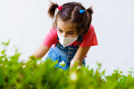 Child girl wearing a protection mask against coronavirus during Covid-19 pandemicの写真素材