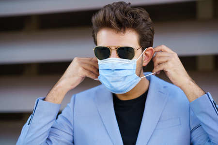 Businessman putting on a surgical mask to protect against the coronavirus.