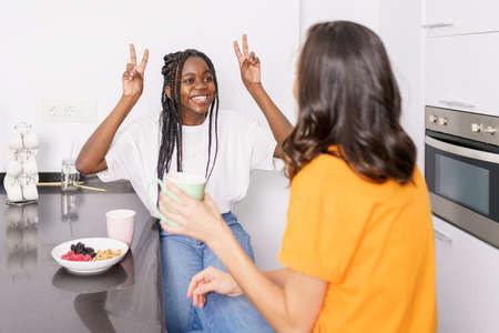 Two friends having a healthy snack while chatting at home