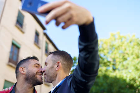 Gay couple making a selfie with their smartphone.の写真素材