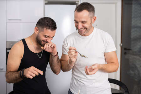 Gay couple cooking healthy vegan food together at home.の写真素材