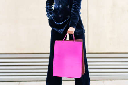Unrecognizable woman with shopping bags in urban background.の写真素材