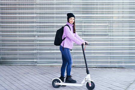 Young woman in her twenties riding an electric scooter.の写真素材