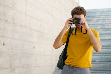 Millennial man taking photographs with a SLR cameraの写真素材