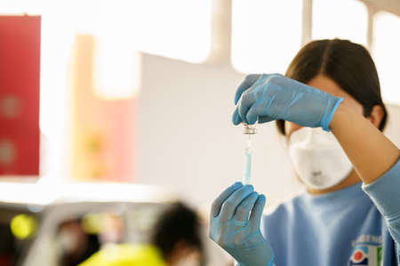 GRANADA, ANDALUSIA, SPAIN. FEBRUARY 26TH, 2021. Mass vaccination against Covid-19, using Astrazenecas vaccine. Nurse loading syringe with vaccine.のeditorial素材