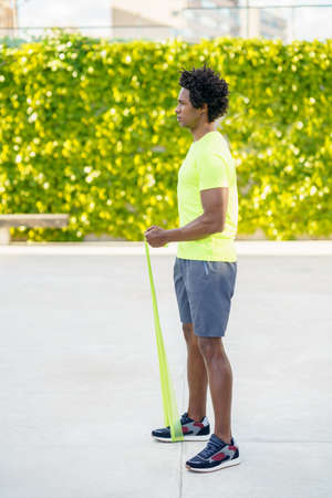 Black man working out with elastic band outdoors