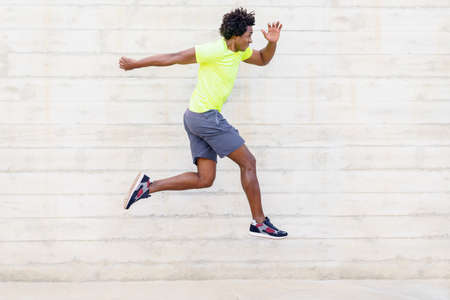 Black man training running jumps to strengthen his legs.