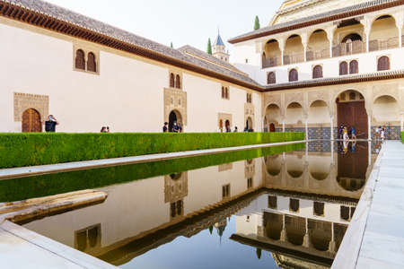 Tourists wearing masks visiting the Comares Palace of the Alhambra in Granada.のeditorial素材