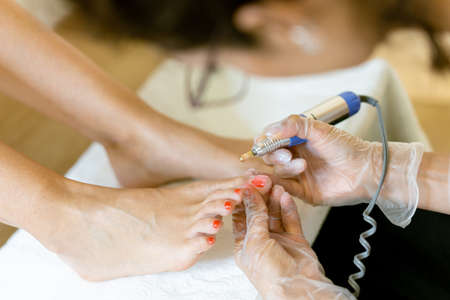 Beautician giving a pedicure painting her clients nails in a beauty centre.の写真素材