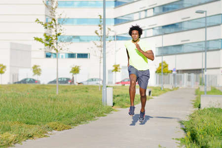 Black athletic man running in an urban park.