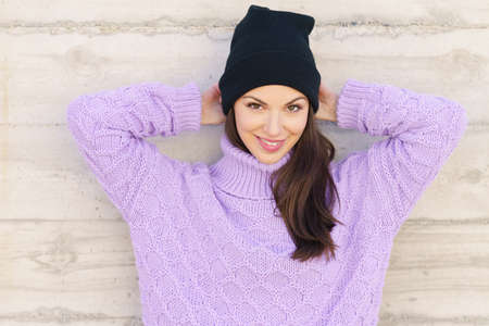 Happy young woman smiling outdoors against urban wall.の写真素材
