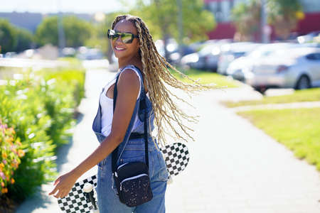 Young black woman moving her coloured braids in the wind. Typical African hairstyle.の写真素材