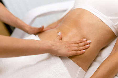 Middle-aged woman having a belly massage in a beauty salon.の写真素材