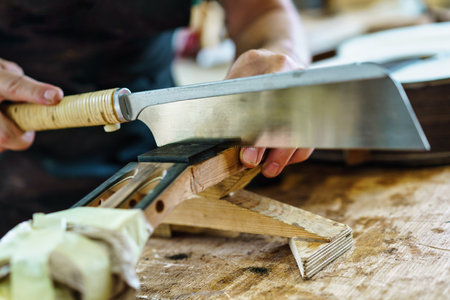 Spanish guitar maker, or luthier, working on a flamenco guitar. Unrecognizable craftsman marking the frets on the neck of a flamenco guitar, as part of the handcrafted manufacturing process.の写真素材