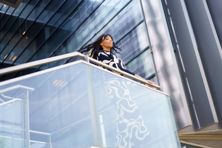 Low angle view photo of a cool woman dancing using rail of an urban stairs