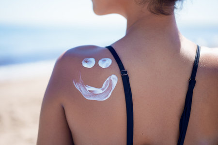 A moisturizing sunscreen lotion with a cheerful smiley face captures the carefree summer vibe, perfect for beach days spent soaking up the sun and enjoying moments of happiness and relaxationの写真素材