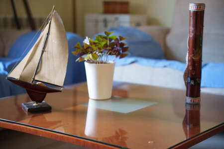 Delicate miniature boat surrounded by retro items, Charming miniature yacht set among nostalgic accessories and vintageinspired decor elementsの写真素材