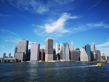 The Lower Manhattan skyline in New York City seen from the ocean on a sunny dayの写真素材