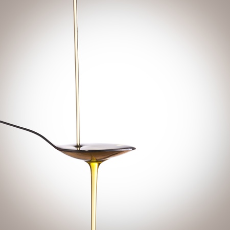 Jet olive oil poured over a spoonの写真素材
