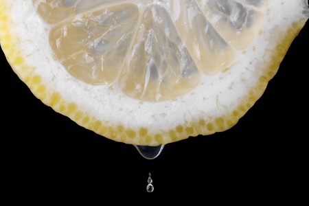 Lemon and drops over a dark backgroundの写真素材
