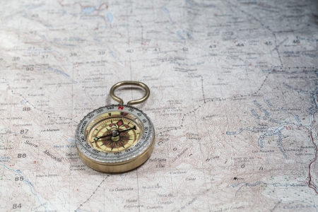 Old compass on a cartographic map of mountainsの写真素材