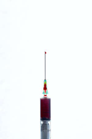 needle of a blood syringe with a drop of blood on the tip with white background verticalの写真素材