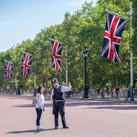 London policeman give information to asian tourist at the Guard Changing parade at Buckingham Palace in London, United Kingdomのeditorial素材