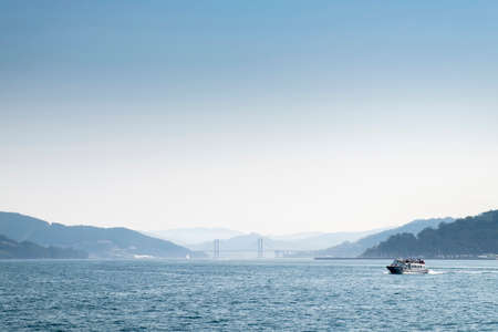 View of the Ria de Vigo from the inside, with the Rande Bridge in the background and a ferry sailing...