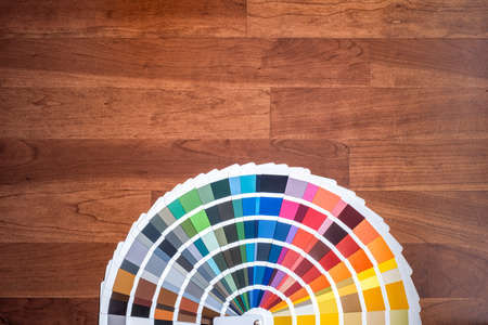 an open color swatch with all the different colors folded out on a wooden surface, cherry colored...