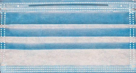 texture of a surgical mask for protection against corona virus in light blue color, closeup of a...