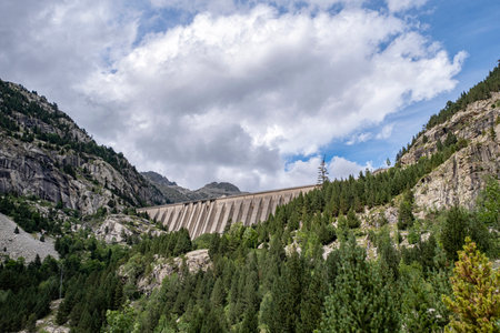 Cavallers reservoir dam seen from below with a cloudy sky, hydroelectric power station in the...