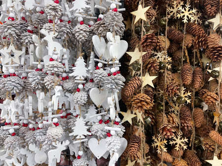 christmas ornaments, Christmas garlands with pine cone, reindeer, holly berries, hearts, snowflakes and stars in white and brown, in a christmas decoration store, horizontalの写真素材