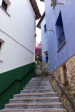narrow street with colorful houses in the picturesque village of Ribadesella, Asturias, Spain, with...