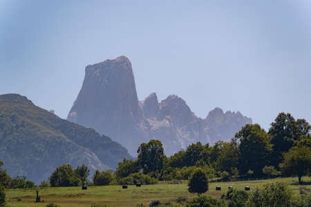 crop fields and pastures in the surroundings of the village of Las Arenas de Cabrales, Asturias, Spain, with the Naranjo de Bulnes of the Picos de Europa, horizontalの写真素材