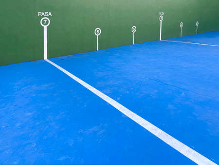 white lines marks with numbers on the green wall and blue floor of a fronton of Basque pelota, wide angle view of a handball or pediment court, with the pasa mark in the foregroundの写真素材