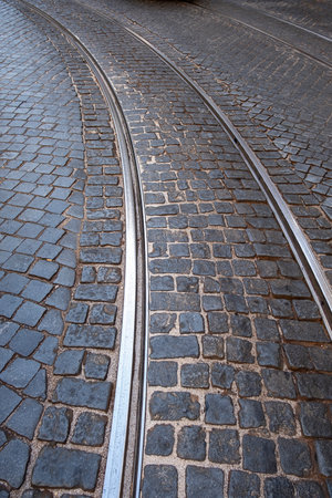 detail of the cobblestone floor of a street in lisbon with the tramway tracks describing a curve in the Alfama district, verticalの写真素材