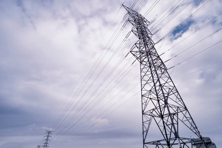 high voltage power lines, high voltage electric transmission tower for producing electricity at high voltage electricity poles, cloudy sky, high voltage pylons horizontalの写真素材