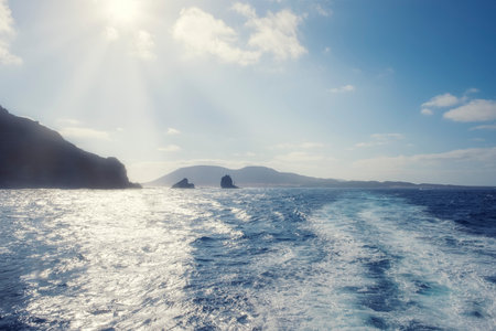 cape of Punta Fariones with the island of La Graciosa in the background backlit by volcanic cliffs on the island of Lanzarote, horizontalの写真素材