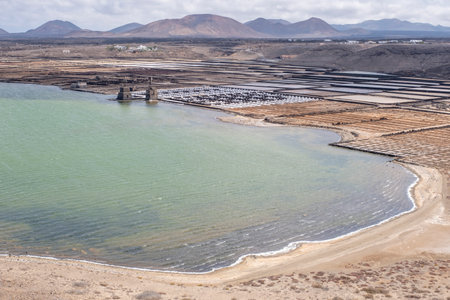 aerial image of a marine salt pan in a bay by the sea, with a volcanic landscape in the background, Janubio salt pan, Lanzarote, Canary Islands, Spain, horizontalの写真素材