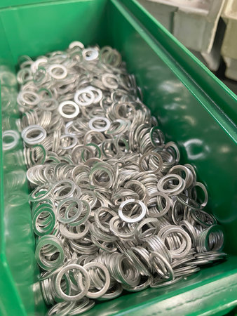 a green drawer in an assembly station of a manufacturing line full of steel washer fastener,...