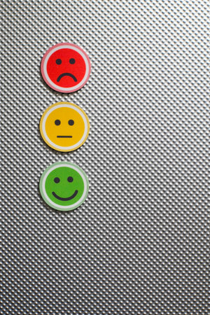 Three round emoji faces in red, yellow, and green representing sad, neutral, and happy emotions on a...