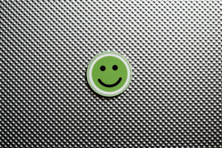round emoji face in green color, representing happy emotions on a metallic textured background, symbolizing feedback of satisfactionの写真素材