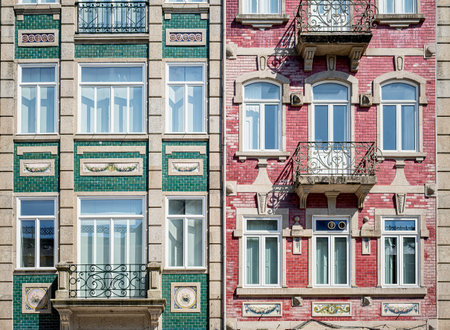 Colorful facade of traditional Portuguese buildings with green and red tiles, ornate balconies, and decorative details in bright daylightの写真素材
