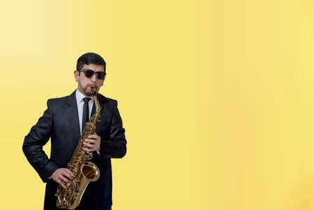 man with sax on yellow backgroundの写真素材
