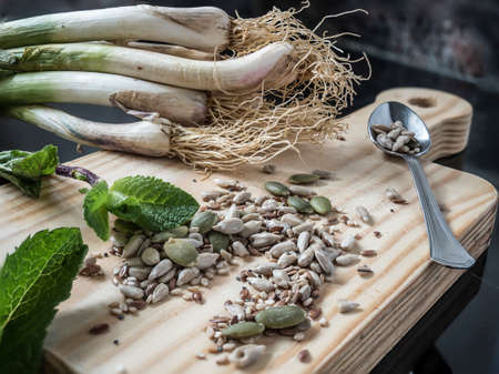 Close-up of young garlic, seeds, mint and spoons.の写真素材