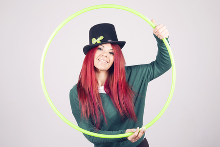 Happy woman celebrating Saint Patrick's day on march 17th, smiling with a green hula hoop.の写真素材