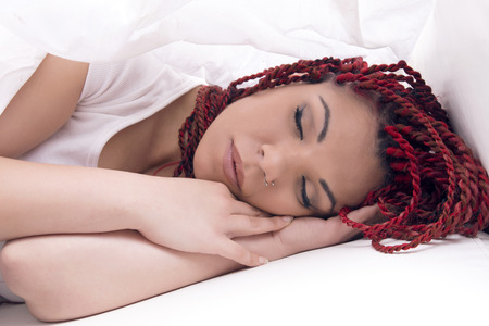 Modern woman sleeping in bed over white sheet, neutral.の写真素材