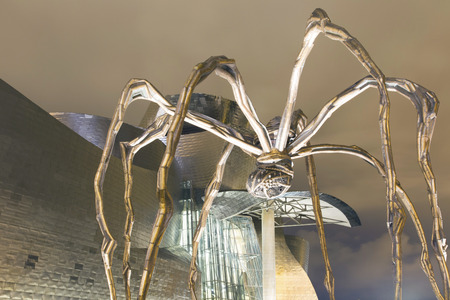Bilbao, Spain - July 26, 2016: Exterior view at night of the north side of the Guggenheim Bilbao Museum. Detail of the head of the "Mother" sculpture by Louise Bourgeois.のeditorial素材